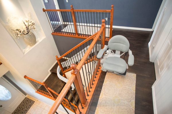 Curved rail stairlift following a turning staircase in a home hallway