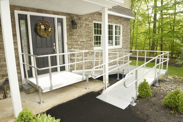 Switchback aluminium wheelchair ramp leading to the front door of a brick home