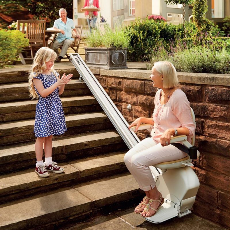 Family member using an outdoor straight stairlift at home