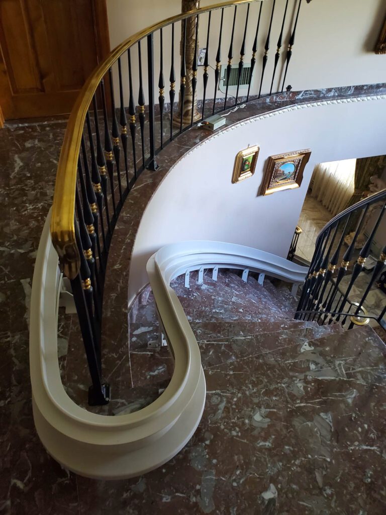 Able Care installers fitting a curved rail stairlift in a home